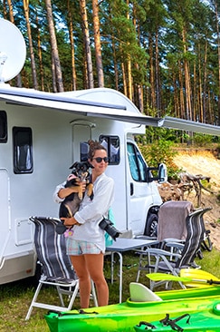 Bild: Frau mit Hund vor Wohnwagen mit Vordach Bild: Frau mit Hund vor Wohnwagen mit Vordach