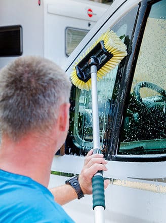 Bild: Mitarbeiter beim Waschen eines Wohnmobil